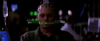 Movie still from “Transcendence” (2014), directed by Wally Pfister – A man with green lights in his mouth; Close Up shot, High angle