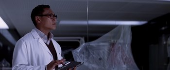 Movie still from “Transcendence” (2014), directed by Wally Pfister – A man in a white lab coat holding a clipboard; Medium shot, Low angle