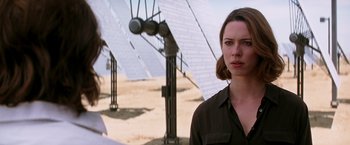 Movie still from “Transcendence” (2014), directed by Wally Pfister – A woman standing in front of some solar panels; Close Up shot, Over the shoulder angle