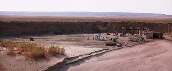 Movie still from “Transcendence” (2014), directed by Wally Pfister – An rv parked on the side of a dirt road; Extreme Wide shot, High angle