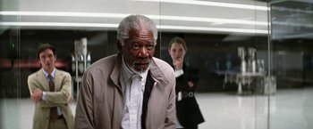 Movie still from “Transcendence” (2014), directed by Wally Pfister – An older man standing next to a young woman; Medium shot, Over the shoulder angle