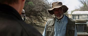 Movie still from “Transcendence” (2014), directed by Wally Pfister – An older man wearing a hat standing next to a bird; Close Up shot, Over the shoulder angle