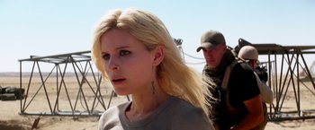 Movie still from “Transcendence” (2014), directed by Wally Pfister – A woman with a tattoo on her neck and a man with a hat in the background; Close Up shot, Over the shoulder angle