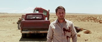 Movie still from “Transcendence” (2014), directed by Wally Pfister – A man standing in front of a red truck; Medium shot, Low angle