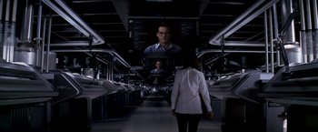Movie still from “Transcendence” (2014), directed by Wally Pfister – A woman in a white lab coat walks down a hallway; Wide shot, Over the shoulder angle