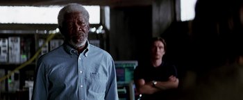 Movie still from “Transcendence” (2014), directed by Wally Pfister – A man standing next to another man in front of a computer monitor; Close Up shot, Over the shoulder angle