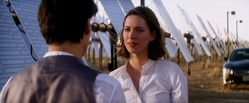 Movie still from “Transcendence” (2014), directed by Wally Pfister – A woman standing next to a man in front of a fence; Close Up shot, Over the shoulder angle