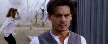 Movie still from “Transcendence” (2014), directed by Wally Pfister – A man in a white shirt and a white vest; Close Up shot, Over the shoulder angle