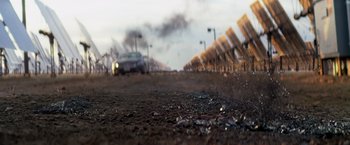 Movie still from “Transcendence” (2014), directed by Wally Pfister – A car is driving down a road with a lot of smoke coming out of it; Extreme Wide shot, Low angle