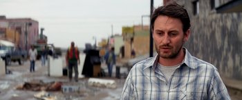 Movie still from “Transcendence” (2014), directed by Wally Pfister – A person wearing a plaid shirt; Close Up shot, Over the shoulder angle