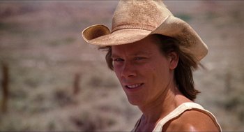 Movie still from “Tremors” (1990), directed by Ron Underwood – A person wearing a cowboy hat; Close Up shot, Low angle