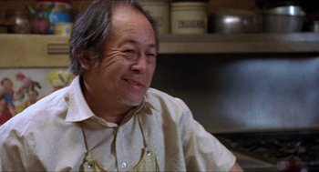 Movie still from “Tremors” (1990), directed by Ron Underwood – An older man wearing an apron in a kitchen; Close Up shot, Low angle
