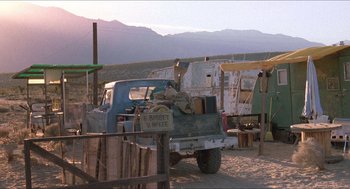 Movie still from “Tremors” (1990), directed by Ron Underwood – An old pick - up truck parked in the dirt; Wide shot, Low angle