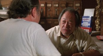 Movie still from “Tremors” (1990), directed by Ron Underwood – Two men are sitting in a room talking to each other; Close Up shot, Low angle