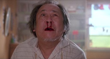 Movie still from “Tremors” (1990), directed by Ron Underwood – An older man with a nose bleed in a room; Close Up shot, Low angle