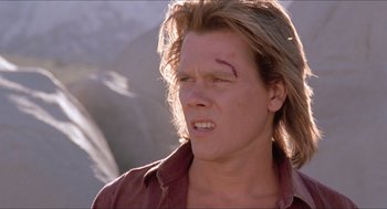 Movie still from “Tremors” (1990), directed by Ron Underwood – A person with a scar on his face; Close Up shot, Low angle