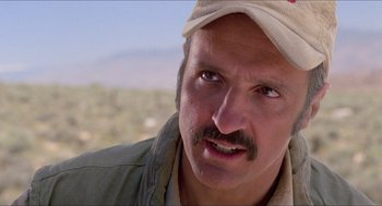 Movie still from “Tremors” (1990), directed by Ron Underwood – A person wearing a hat; Close Up shot, Low angle