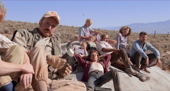 Movie still from “Tremors” (1990), directed by Ron Underwood – A group of people sitting on top of a hill; Wide shot, Low angle