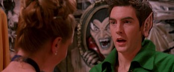 Movie still from “Trick 'r Treat” (2007), directed by Michael Dougherty – A man and a woman talking in front of an evil face; Close Up shot, Over the shoulder angle