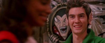 Movie still from “Trick 'r Treat” (2007), directed by Michael Dougherty – A young man smiling in front of a picture of dracula; Close Up shot, Over the shoulder angle