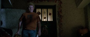 Movie still from “Trick 'r Treat” (2007), directed by Michael Dougherty – A young man standing in front of a door; Medium shot, Low angle