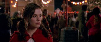 Movie still from “Trick 'r Treat” (2007), directed by Michael Dougherty – A woman in a red coat standing next to a crowd of onlookers; Close Up shot, Over the shoulder angle