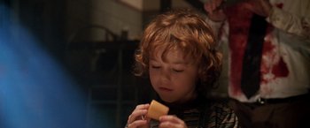 Movie still from “Trick 'r Treat” (2007), directed by Michael Dougherty – A young child holding a piece of food; Close Up shot, Over the shoulder angle