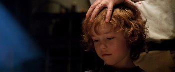 Movie still from “Trick 'r Treat” (2007), directed by Michael Dougherty – A person touching the head of a young child; Close Up shot, Over the shoulder angle