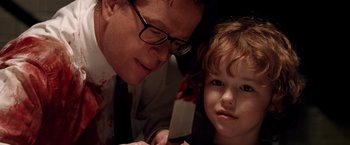 Movie still from “Trick 'r Treat” (2007), directed by Michael Dougherty – A man and a child are holding a knife in their hands; Close Up shot, Over the shoulder angle