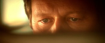 Movie still from “Trick 'r Treat” (2007), directed by Michael Dougherty – An older man's eyes are seen through a window; Extreme Close Up shot, Overhead angle
