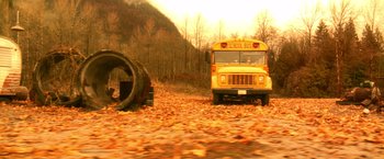 Movie still from “Trick 'r Treat” (2007), directed by Michael Dougherty – A yellow school bus driving down a road in the woods; Extreme Wide shot, High angle