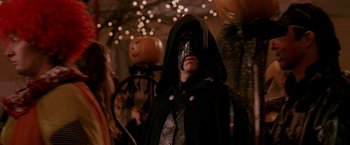 Movie still from “Trick 'r Treat” (2007), directed by Michael Dougherty – A man in a black mask and a black cape; Medium shot, Low angle