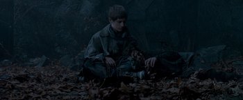 Movie still from “Trick 'r Treat” (2007), directed by Michael Dougherty – A young boy sitting on the ground in the leaves; Medium shot, High angle