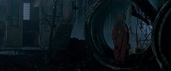 Movie still from “Trick 'r Treat” (2007), directed by Michael Dougherty – A person dressed as a person in a red suit standing in a tunnel; Wide shot, Low angle