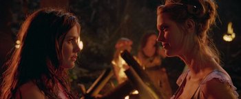 Movie still from “Trick 'r Treat” (2007), directed by Michael Dougherty – A group of people standing around a fire pit at night; Close Up shot, Over the shoulder angle