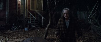 Movie still from “Trick 'r Treat” (2007), directed by Michael Dougherty – An old man holding a baseball bat in a yard; Medium shot, Over the shoulder angle