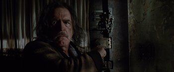 Movie still from “Trick 'r Treat” (2007), directed by Michael Dougherty – A person holding a gun in a dark room; Close Up shot, Low angle