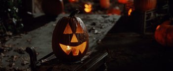 Movie still from “Trick 'r Treat” (2007), directed by Michael Dougherty – A jack - o - lantern sitting on a table; Extreme Close Up shot, High angle