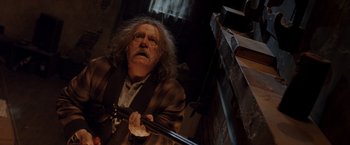 Movie still from “Trick 'r Treat” (2007), directed by Michael Dougherty – An old man holding a sword in a dark room; Medium shot, Low angle