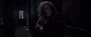 Movie still from “Trick 'r Treat” (2007), directed by Michael Dougherty – An old man holding a sword in a dark room; Medium shot, Low angle