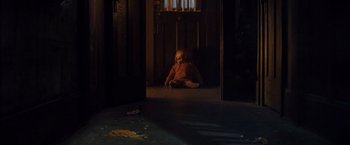 Movie still from “Trick 'r Treat” (2007), directed by Michael Dougherty – A doll sitting on the floor in a dark room; Wide shot, High angle