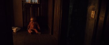 Movie still from “Trick 'r Treat” (2007), directed by Michael Dougherty – A child sitting on the floor in a dark room; Wide shot, High angle