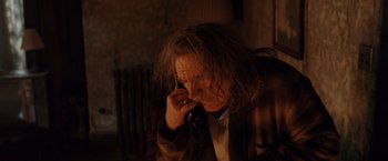 Movie still from “Trick 'r Treat” (2007), directed by Michael Dougherty – A person on the phone in a dark room; Medium shot, High angle