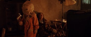 Movie still from “Trick 'r Treat” (2007), directed by Michael Dougherty – A person with a teddy bear sitting next to another person; Medium shot, Over the shoulder angle