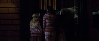 Movie still from “Trick 'r Treat” (2007), directed by Michael Dougherty – Two children are standing in a room looking at a window; Medium shot, Over the shoulder angle