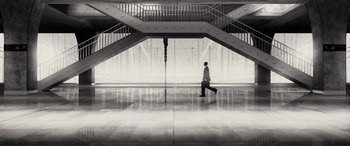Movie still from “Triple 9” (2016), directed by John Hillcoat – A man is walking in a building with stairs; Extreme Wide shot, Low angle