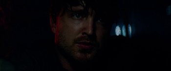 Movie still from “Triple 9” (2016), directed by John Hillcoat – A person with a light in the background; Close Up shot, Over the shoulder angle