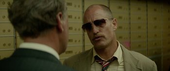 Movie still from “Triple 9” (2016), directed by John Hillcoat – A man in a suit and sunglasses talking to another man in a suit; Close Up shot, Low angle