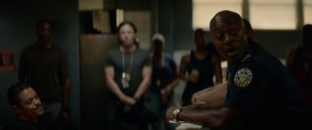 Movie still from “Triple 9” (2016), directed by John Hillcoat – A group of people standing in front of a wall; Medium shot, Over the shoulder angle