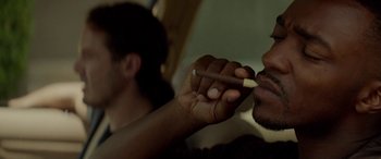 Movie still from “Triple 9” (2016), directed by John Hillcoat – A person holding a pencil in their hand; Close Up shot, Over the shoulder angle